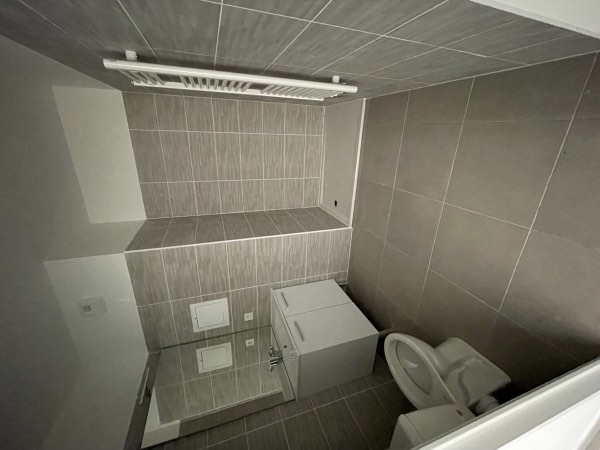 Salle de bain rénovée : douche, meuble vasque, WC et sèche-serviettes